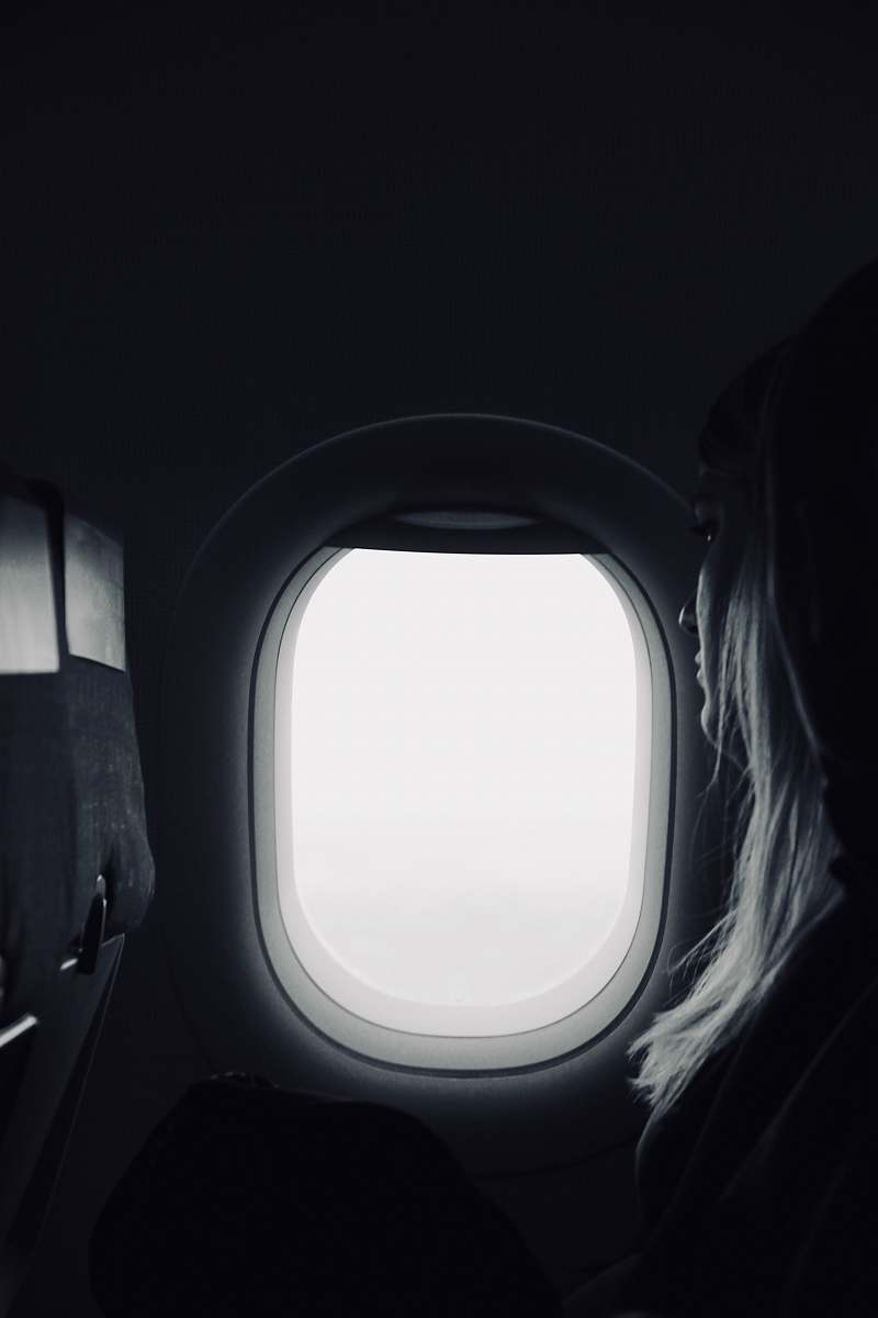 porthole person sitting beside airplane window airplane