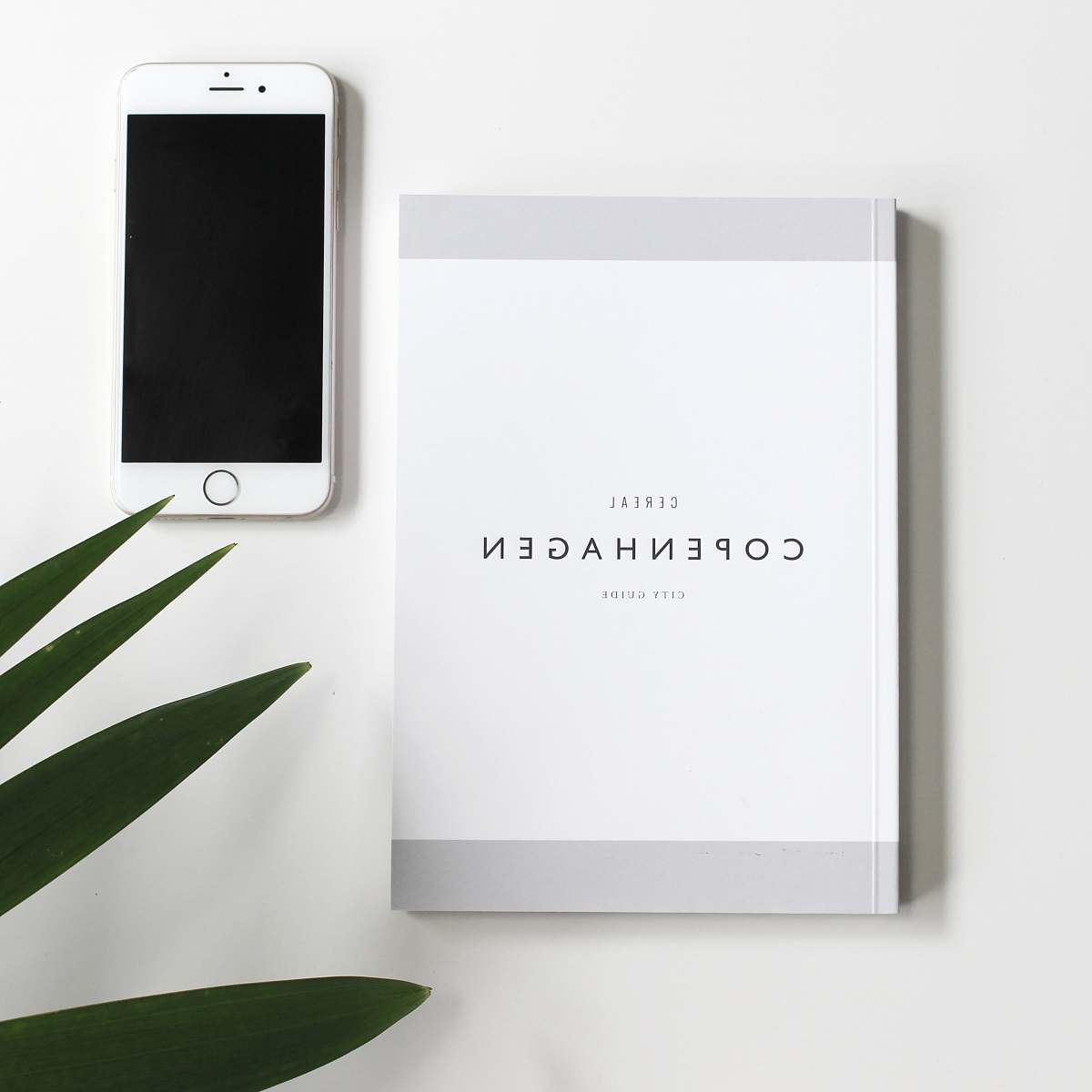 australia Copenhagen book beside iPhone 6 white