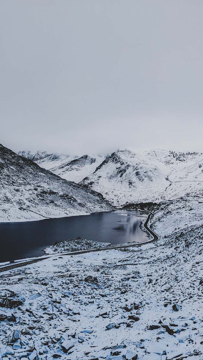 snow body of water between mountain grey
