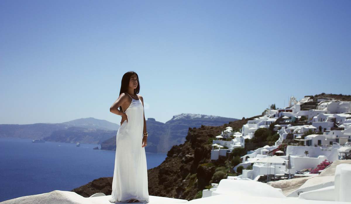 dress woman wearing white dress in front building beside sea greece
