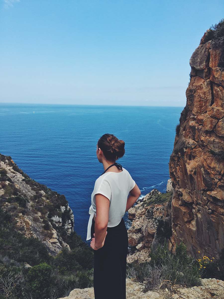  woman standing near mountain cliff 