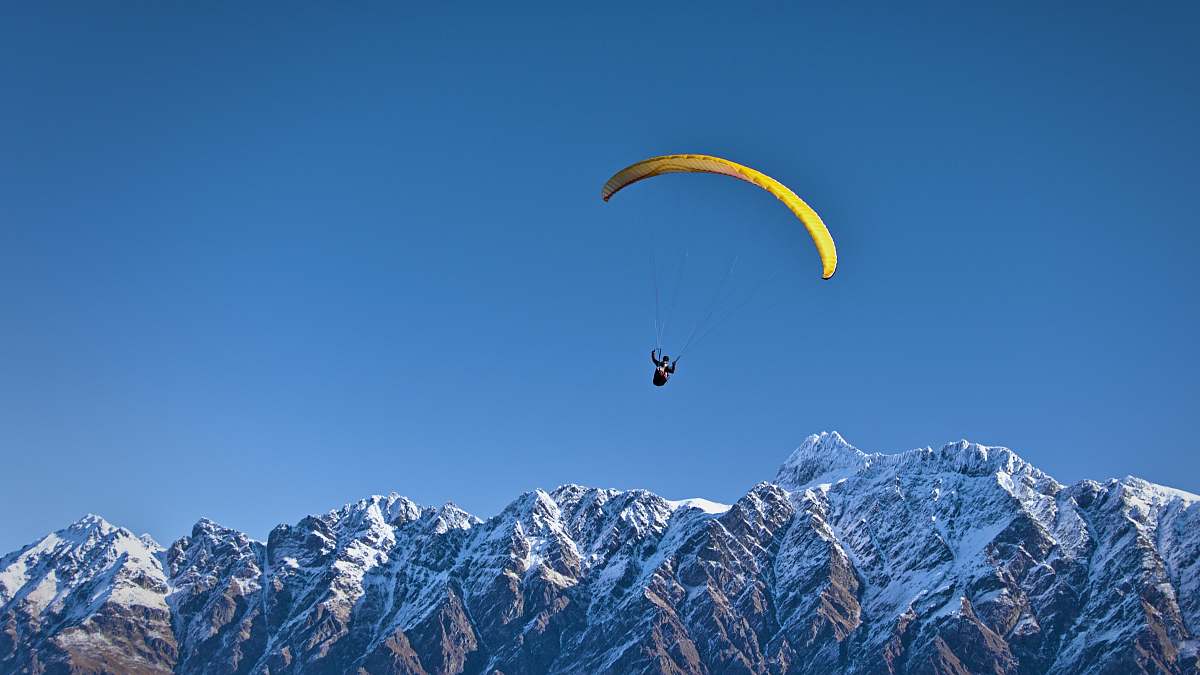 paraglide man on parachute near the mountain paragliding