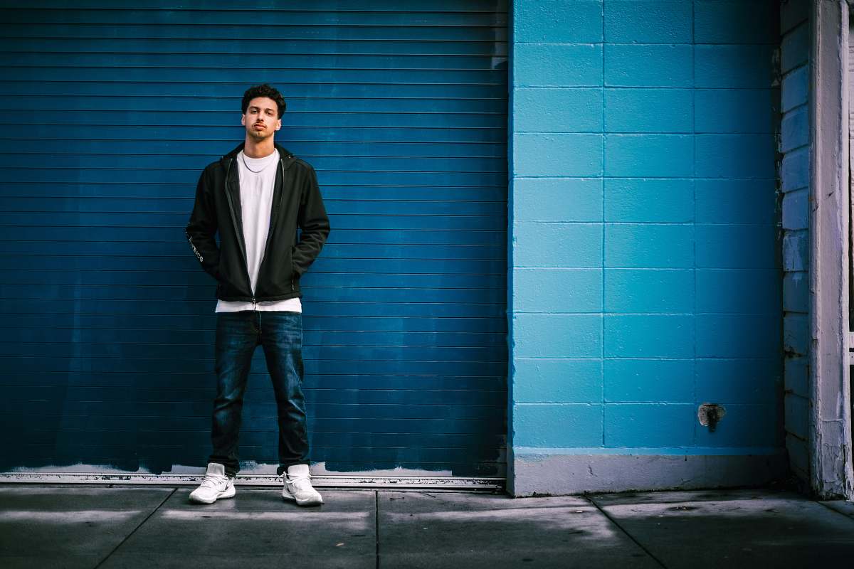 clothing man standing in front of blue roller shutter shoe