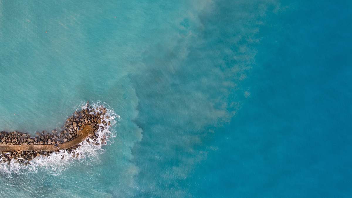 sea aerial photography of islet during daytime water