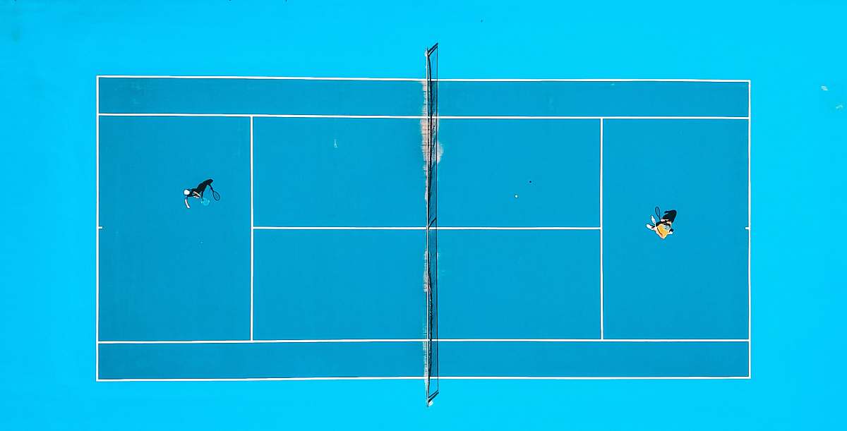 sport aerial photography of two person playing tennis drone view