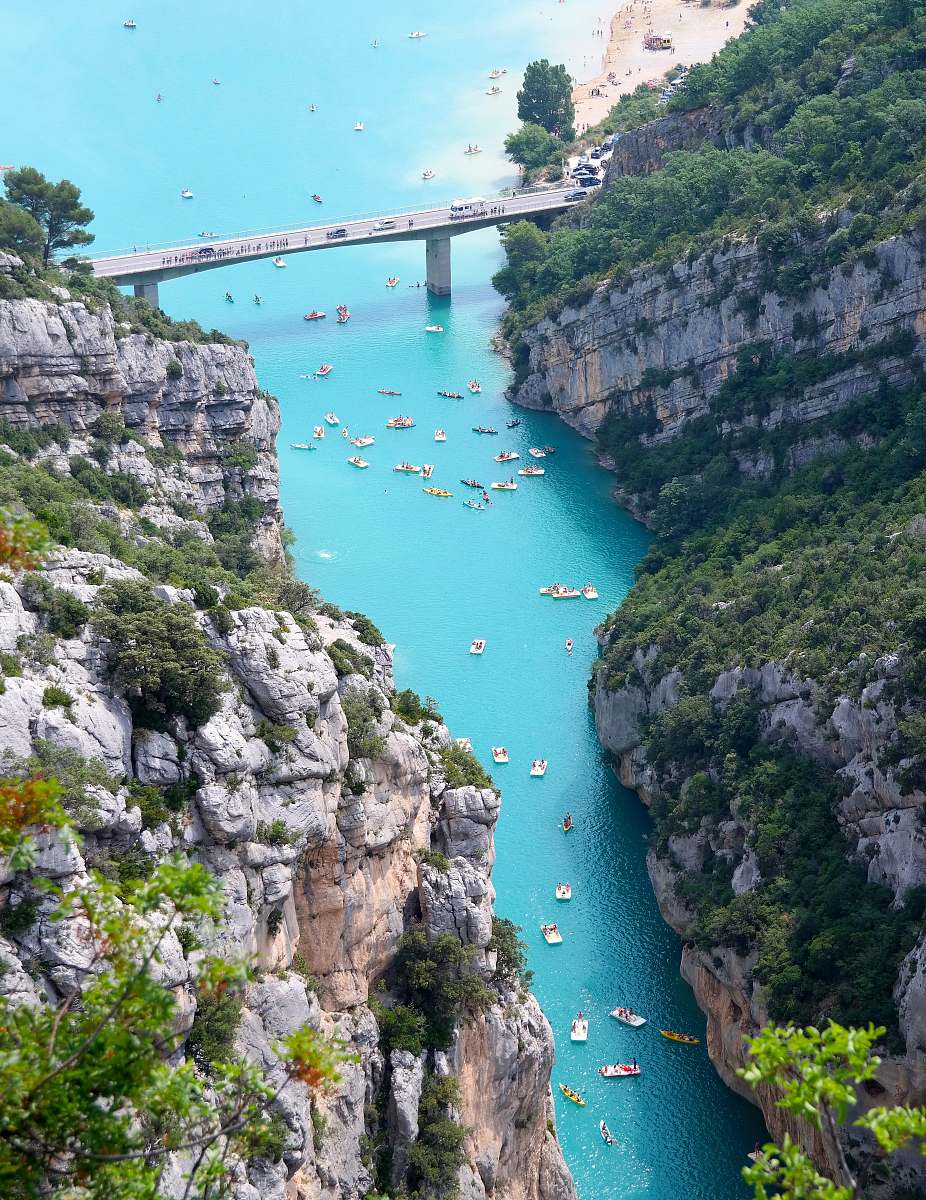lake aerial view of boats on body of water beside mountain bridge