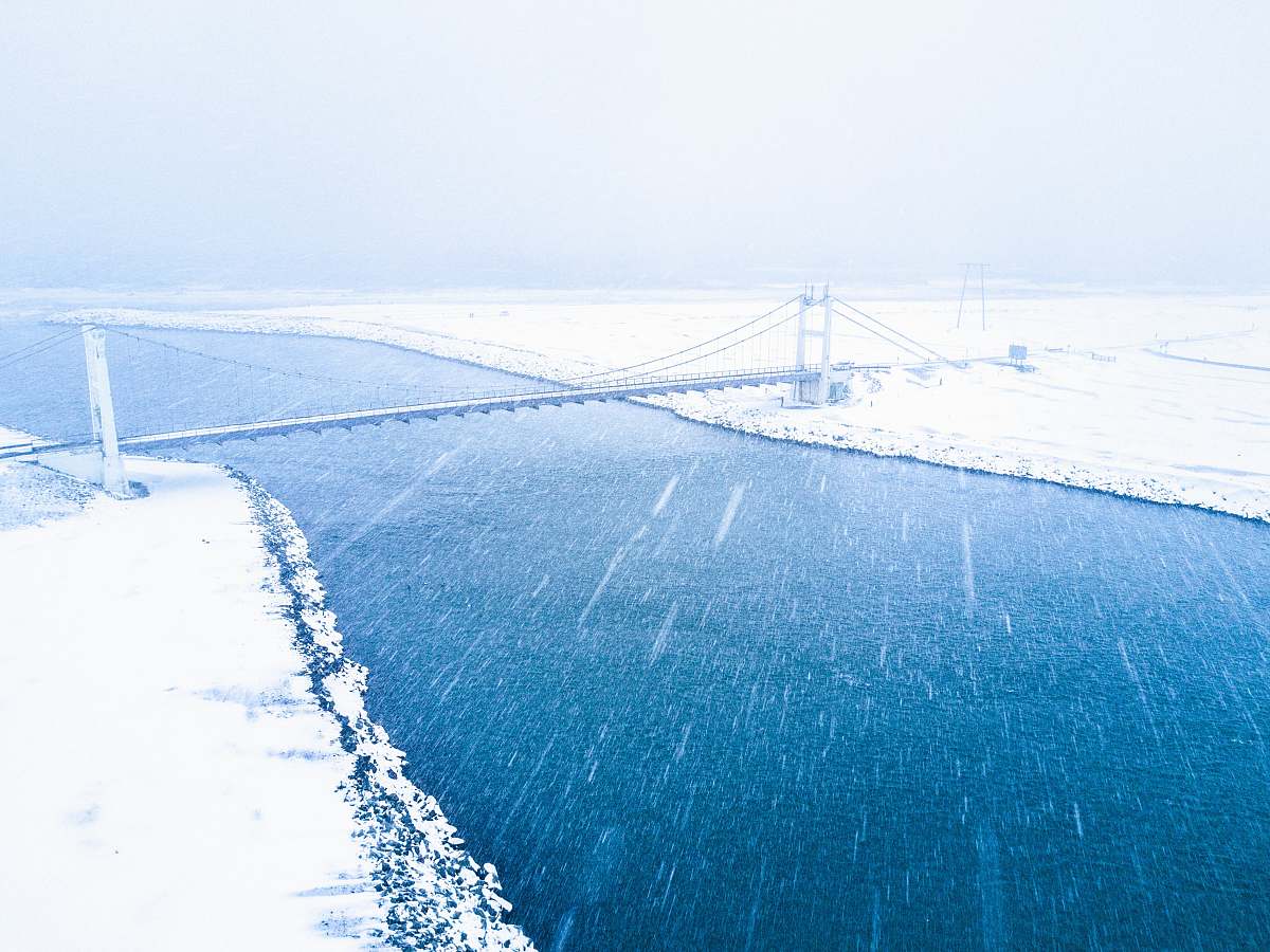 snow aerial view of bridge coat snow over body of water winter