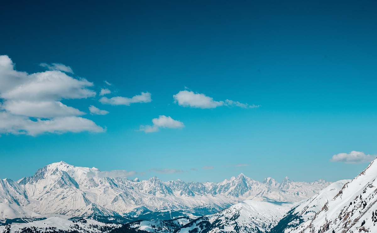 mountain aerial view of snow covered mountains sky