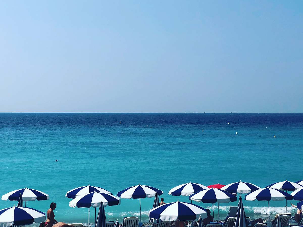 human blue and white patio umbrella near at seashore person