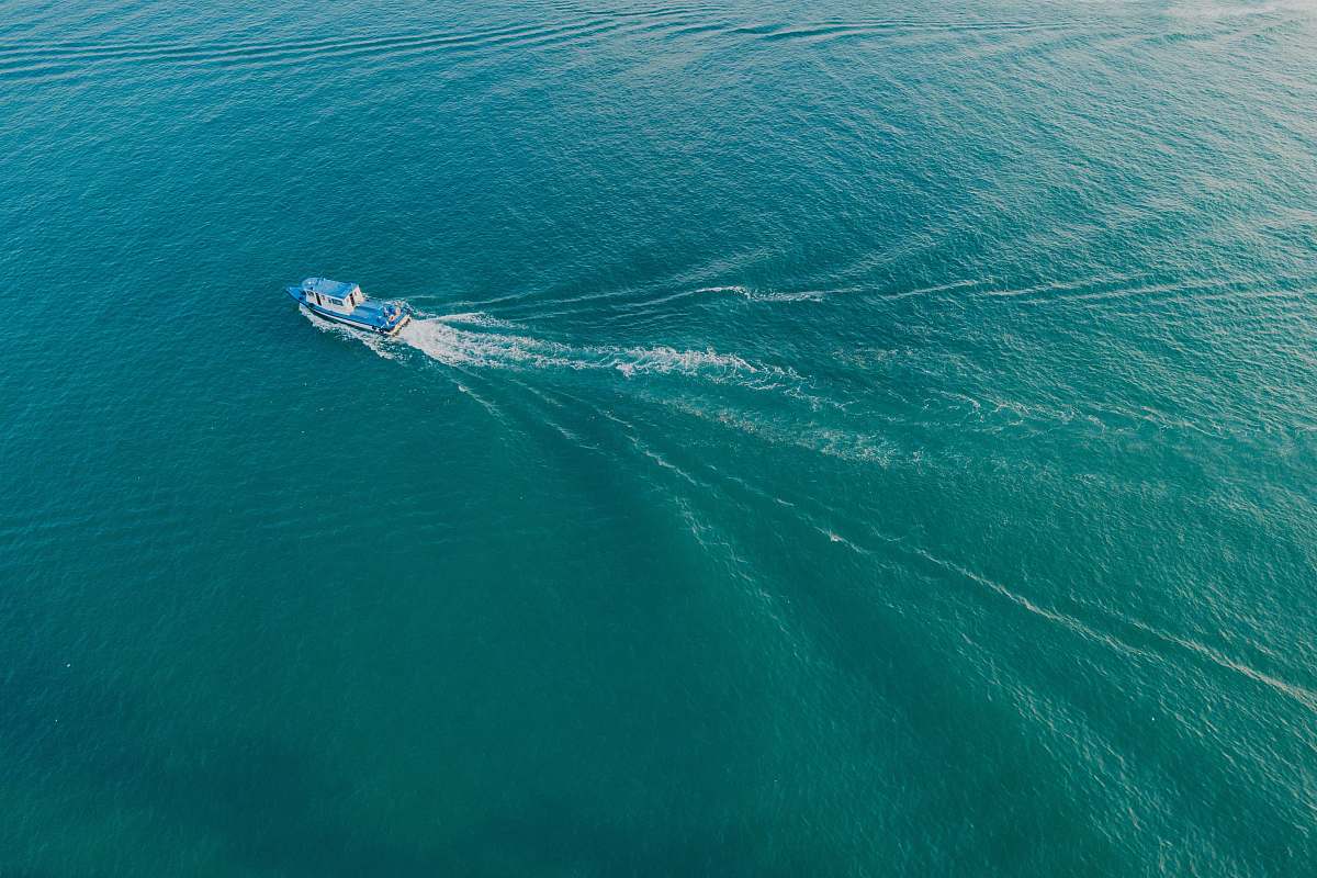teal body of water with boat ocean