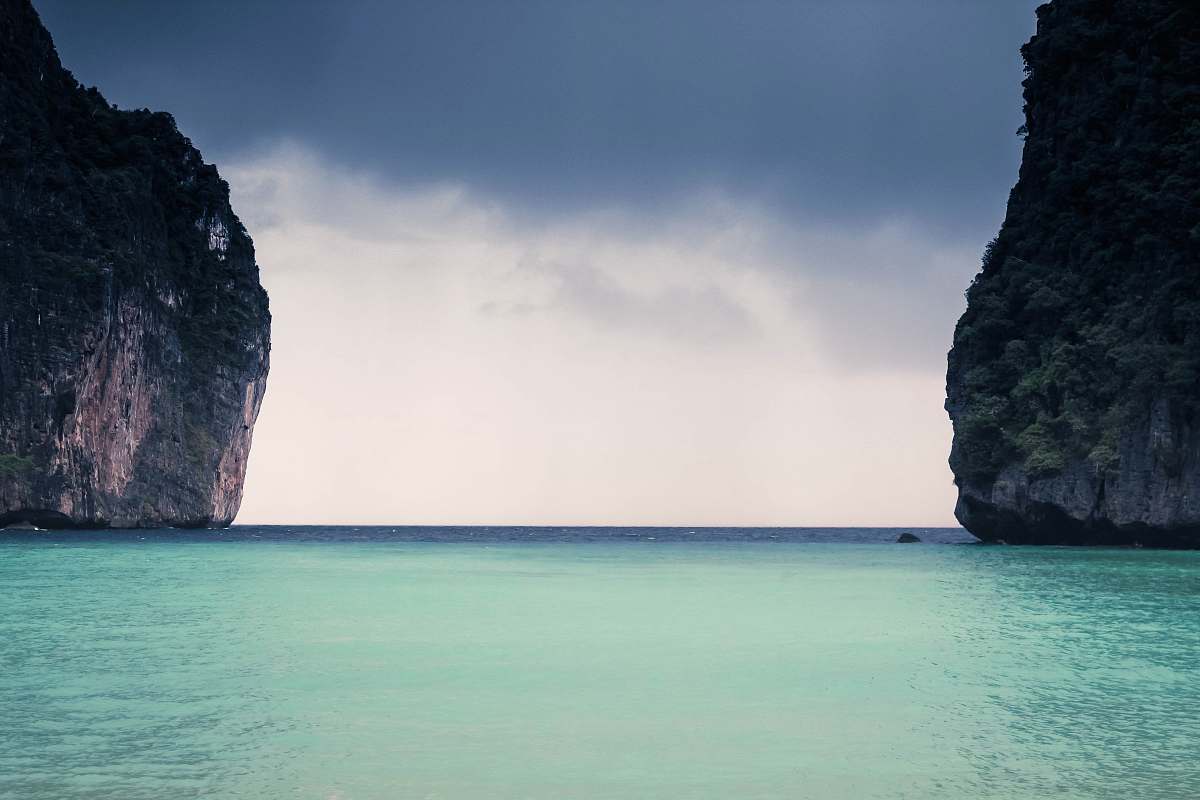 nature body of water with of two rock formations during daytime sky