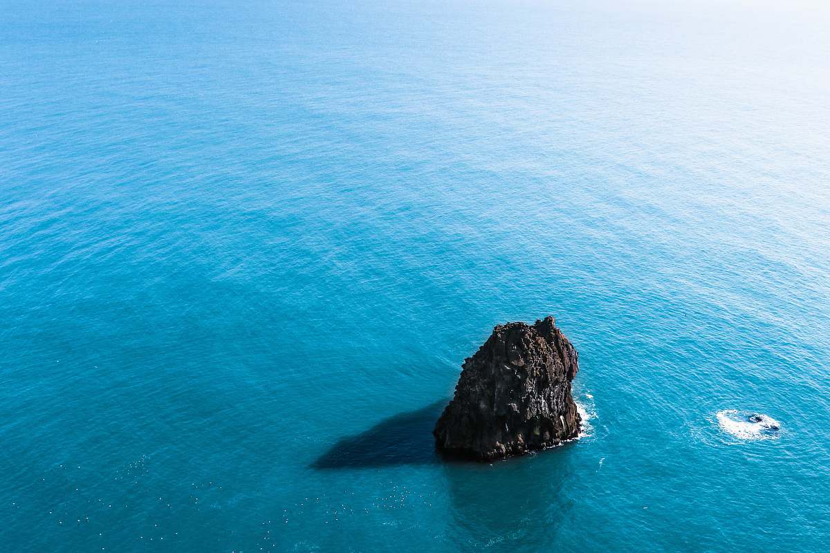 water brown rock formation on body of water sea