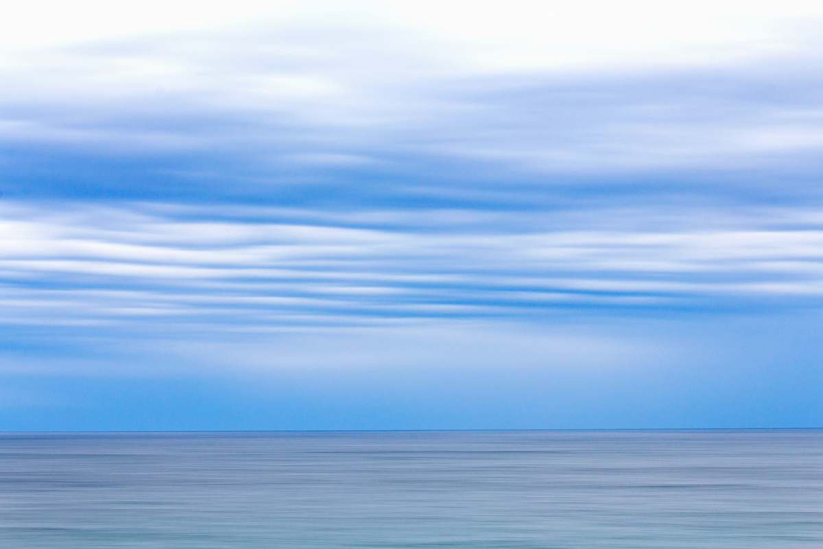 Experience the serene beauty of a calm sky adorned with soft clouds, perfectly framing a breathtaking ocean view from the elevated vantage of a hill. This idyllic scene captures the essence of tranquility and is ideal for use in travel brochures, website backgrounds, or as calming artwork in homes and offices. Perfect for evoking feelings of peace and relaxation, this image is a must-have for any creative project focused on nature or coastal landscapes.