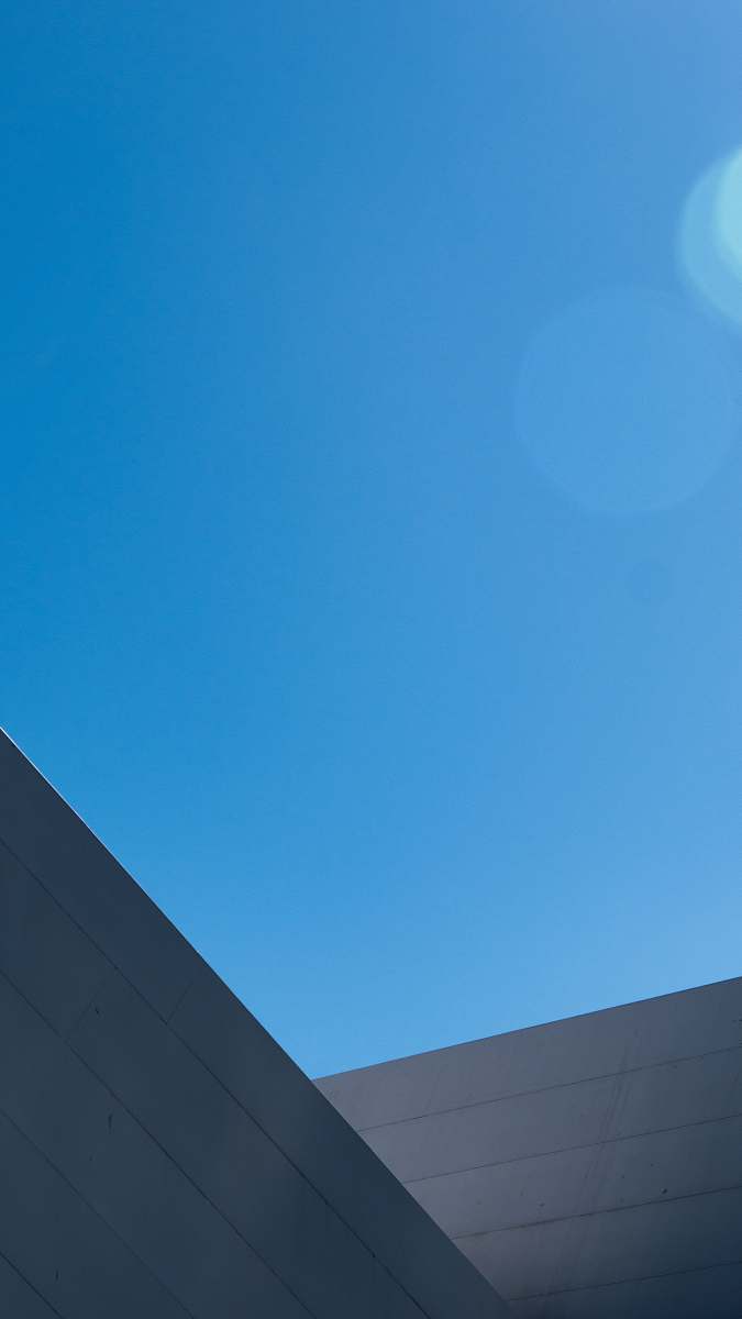 Experience the beauty of contemporary architecture with this close-up photograph showcasing intricate building details under a pristine blue sky. Ideal for use in real estate brochures, architectural portfolios, or as striking wall art, this image captures the essence of urban sophistication and design excellence.