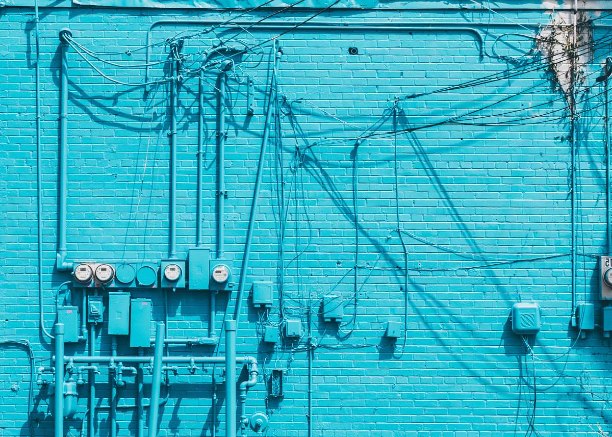 wall electric meter on blue brick wall wires