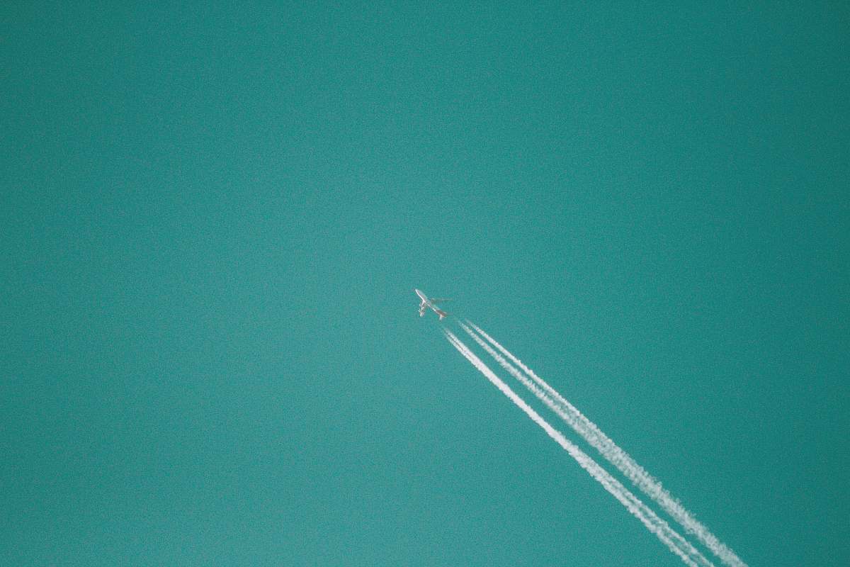 plane flying jet plane releasing white smoke sky