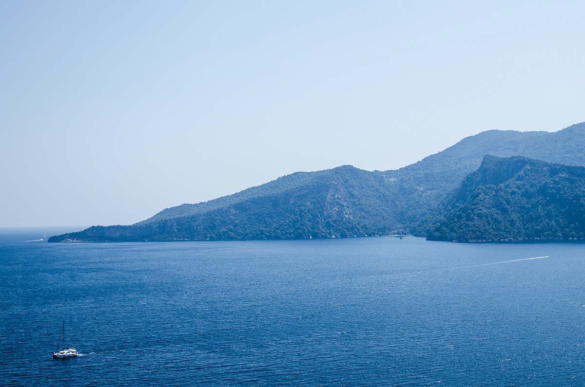 water landscape photography of sea and mountains under blue calm sky turkey