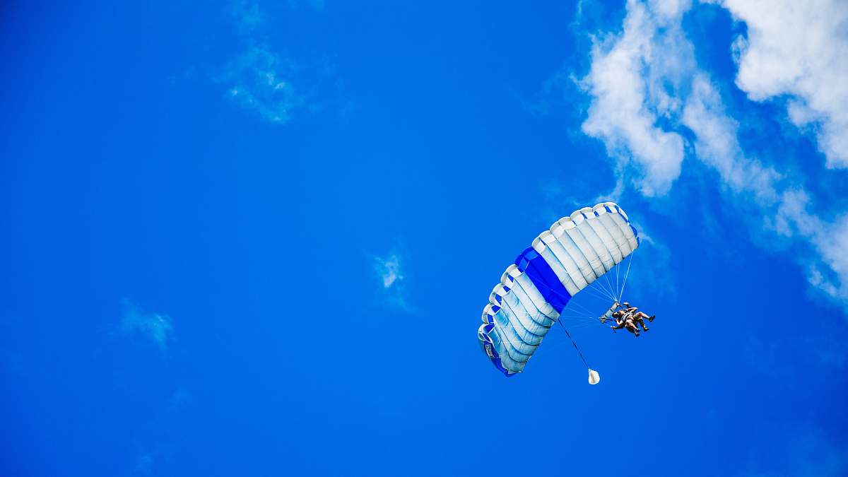 parachute low-angle photography of person riding fan-powered chair with parachute up in sky sky