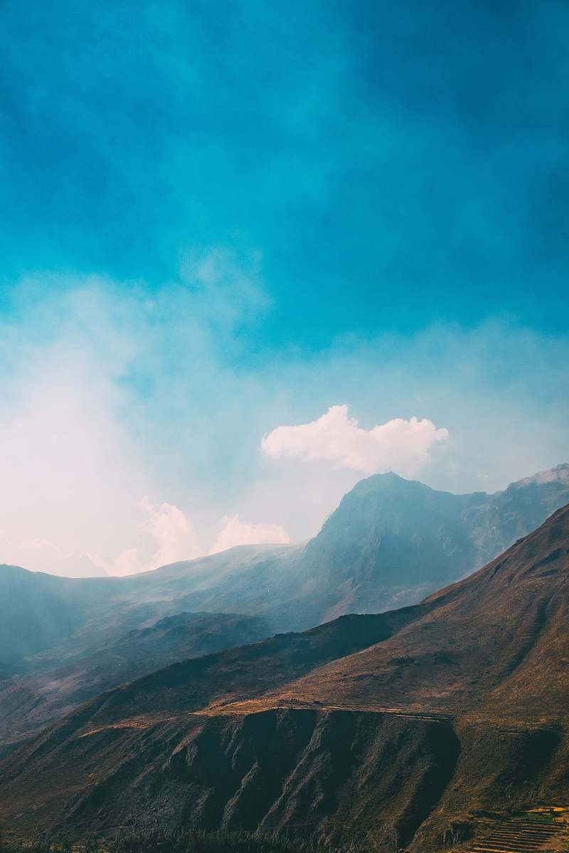 mountain mountain view under blue sky mist