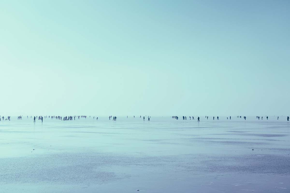 winter people walking in seashore over the horizon during daytime snow