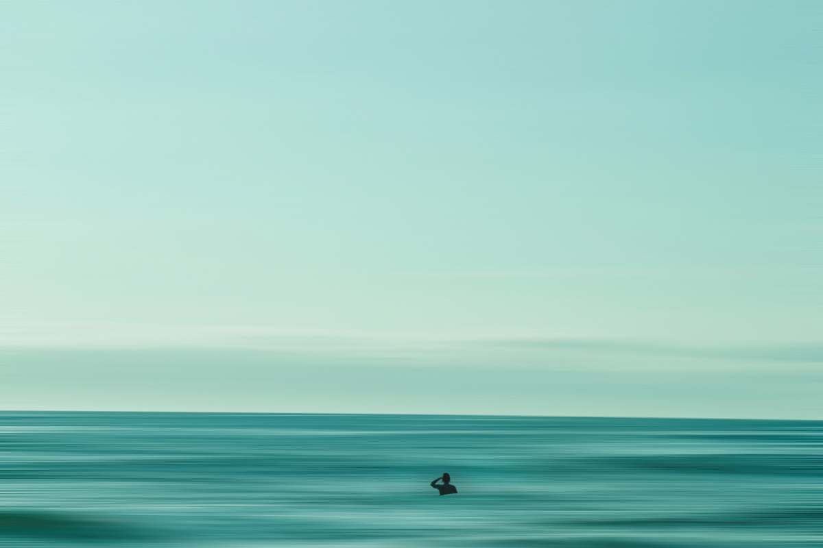 water person in middle of ocean during daytime horizon