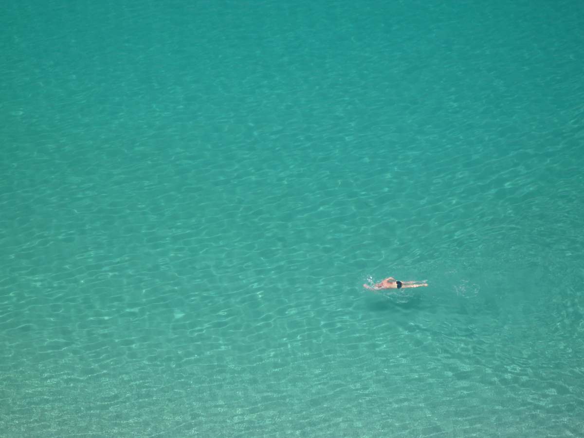 teal person swimming on body of water ocean