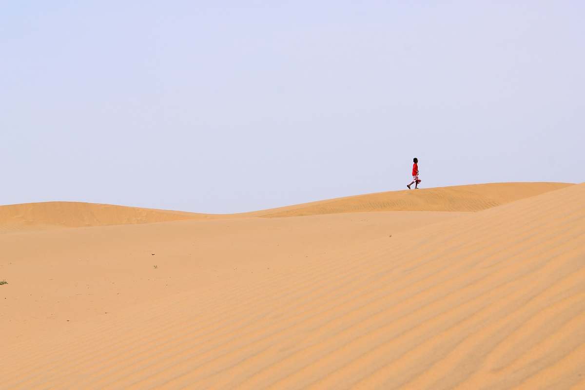 sand person walking on desert desert