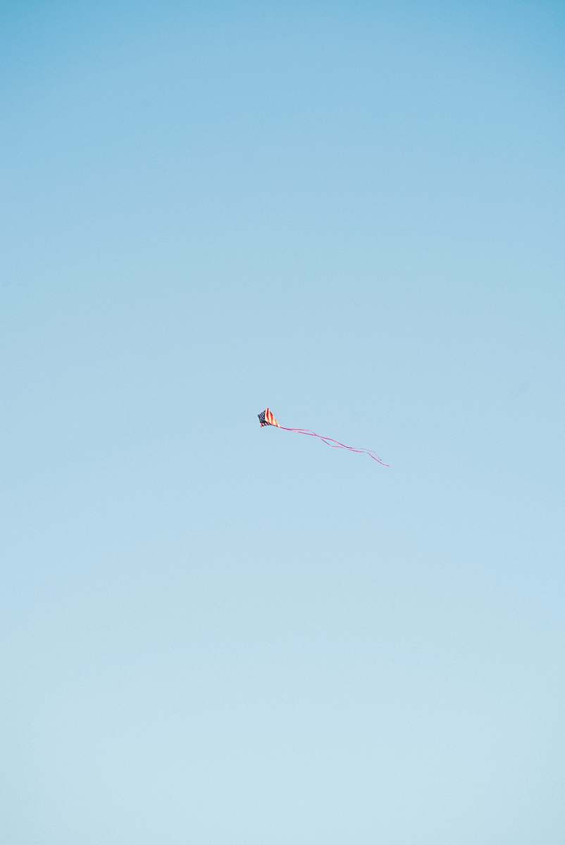 adventure red and white kite flying in the sky gliding