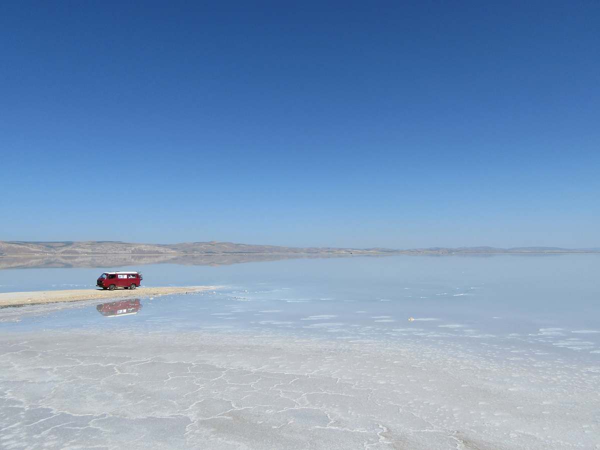 turkey red and white van near sea under blue sky lake