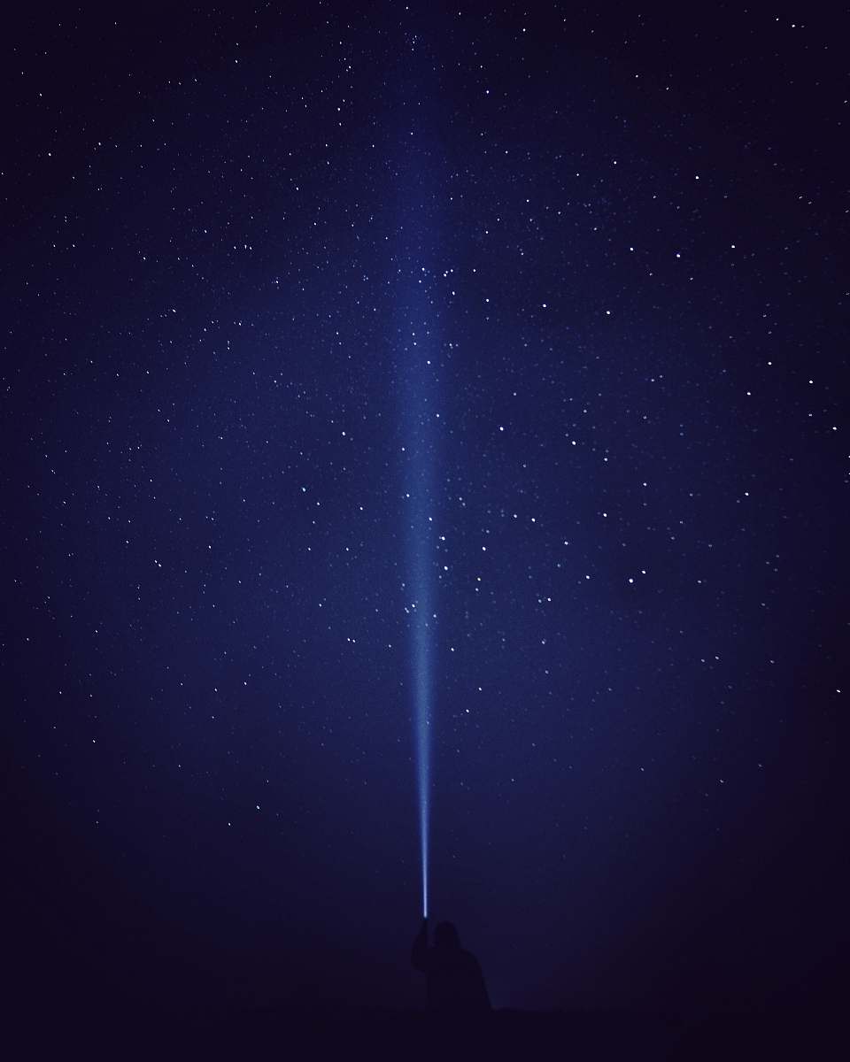 astronomy silhouette of person with flash light under starry night galaxy