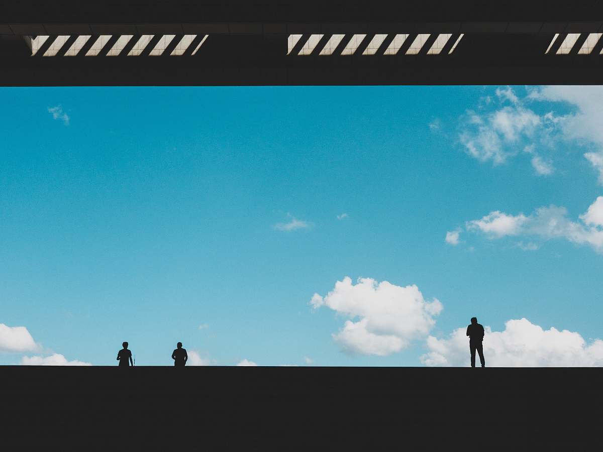 building silhouette of three person against blue sky landing page