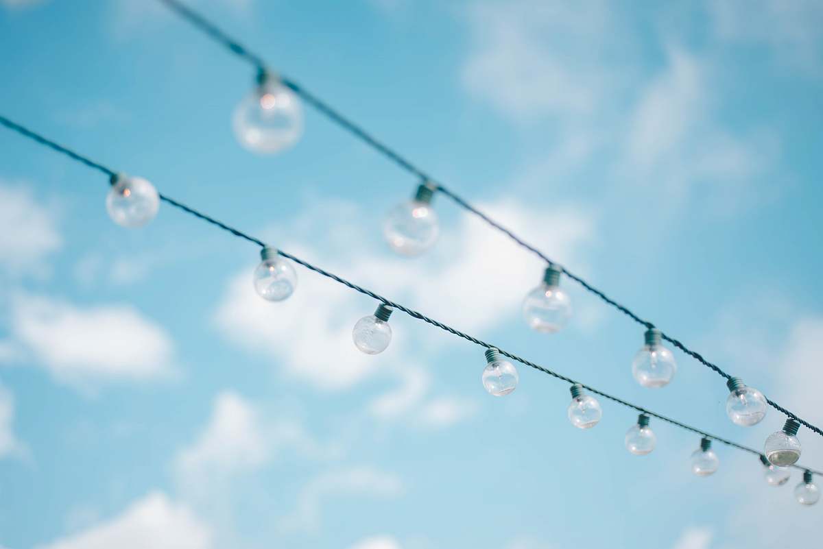 person tilt lens photography of string lights under cloudy skies human