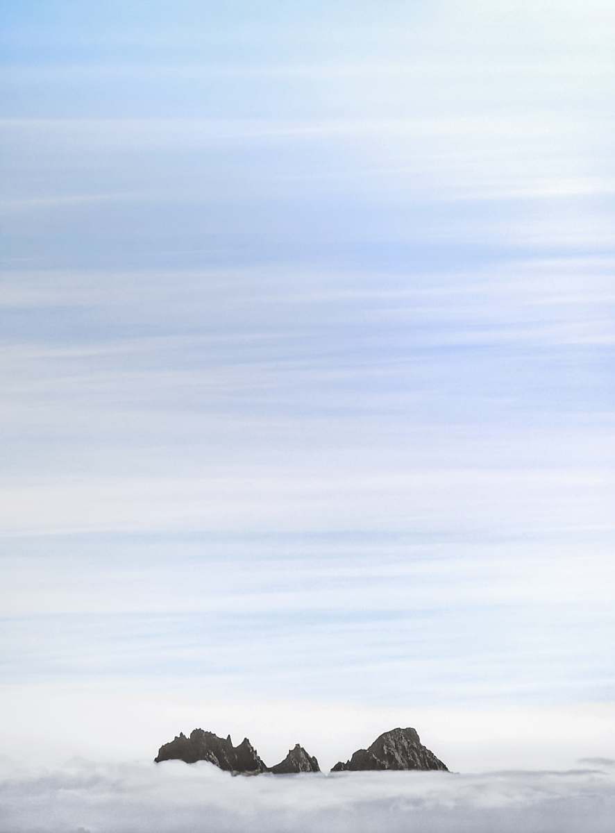 snow tip of mountain peeping on clouds winter