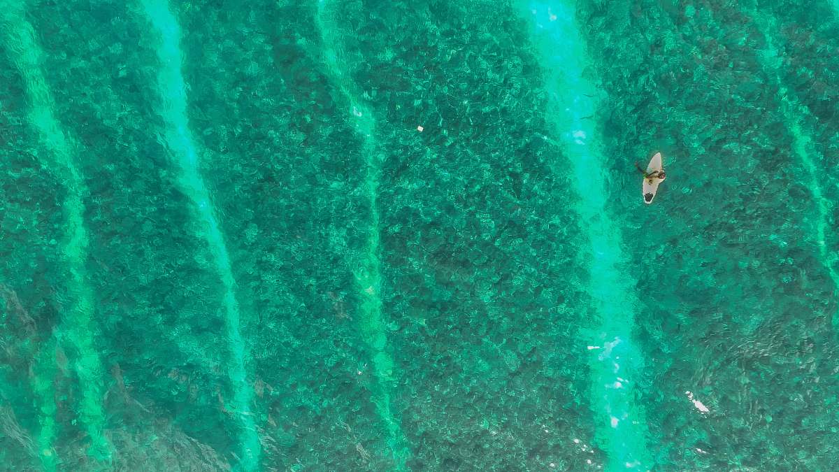 teal top view of white boat on body of water during daytime maldives