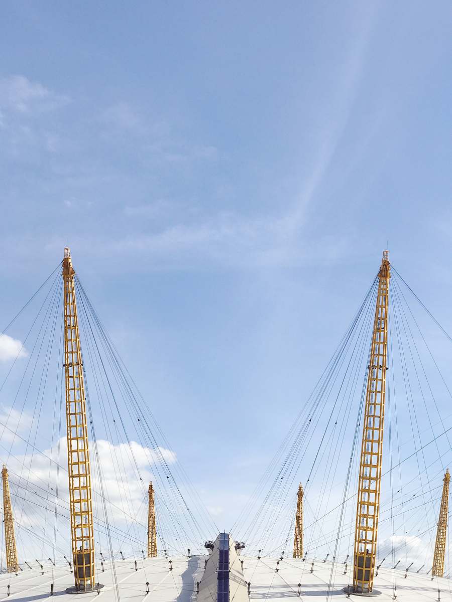 london two yellow cable towers under blue sky the o2 arena