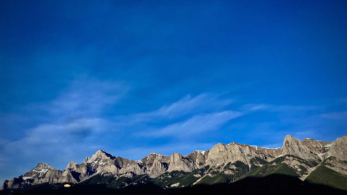 mountain white clouds above gray rock formations mountain range