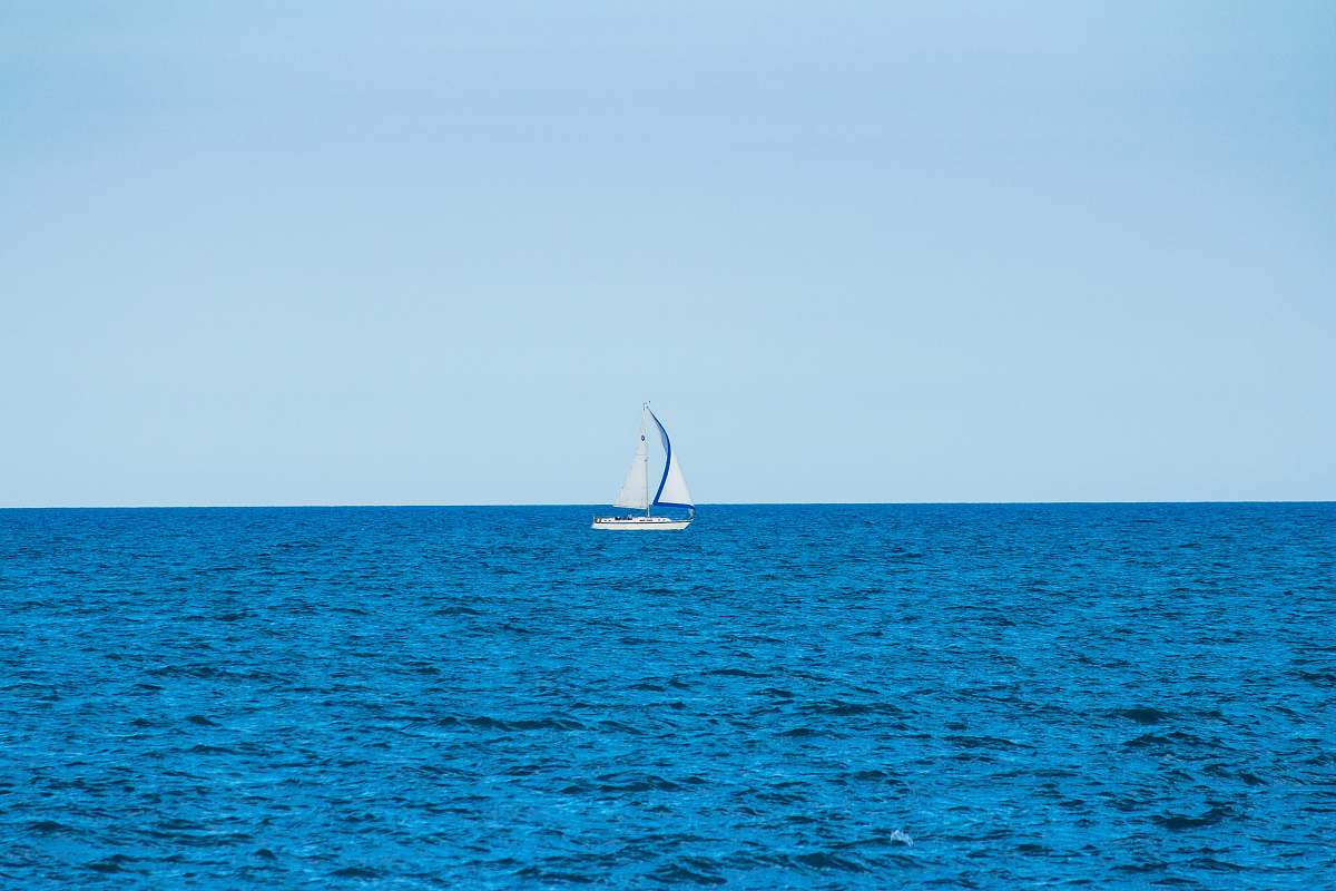 boat white sailboat in the middle of the ocean during day transportation