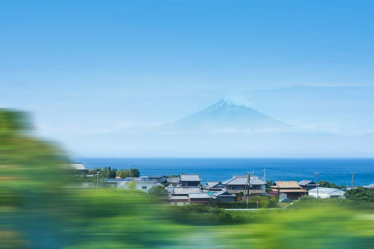 blue timelapse photo of house near ocean across Mt. Fuji sea