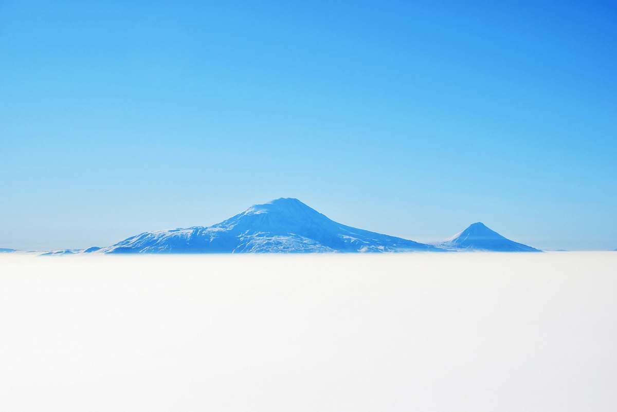 Experience the breathtaking beauty of a snow-covered outdoor landscape featuring majestic white mountains in the background. This serene scene captures the essence of winter tranquility, making it perfect for travel brochures, nature-themed websites, and winter sports advertisements. Ideal for evoking feelings of adventure and exploration, this image can transport viewers to a pristine, snowy wonderland.