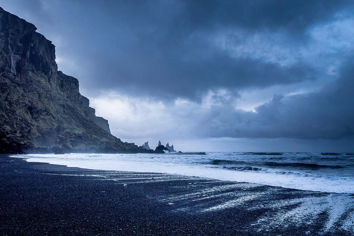 beach seashore near mountains during twilight coast