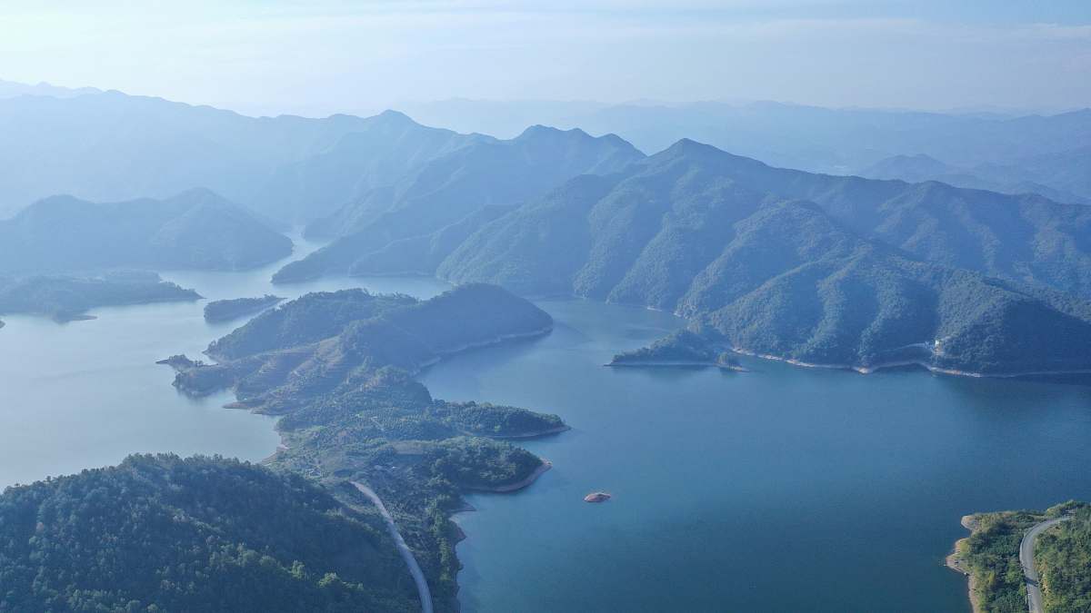 nature aerial photography of body of water viewing mountain under blue and white sky land