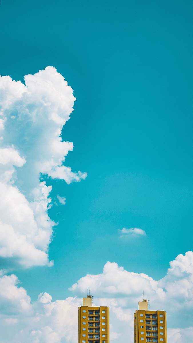 sky two brown tall buildings under white sky during daytime azure sky