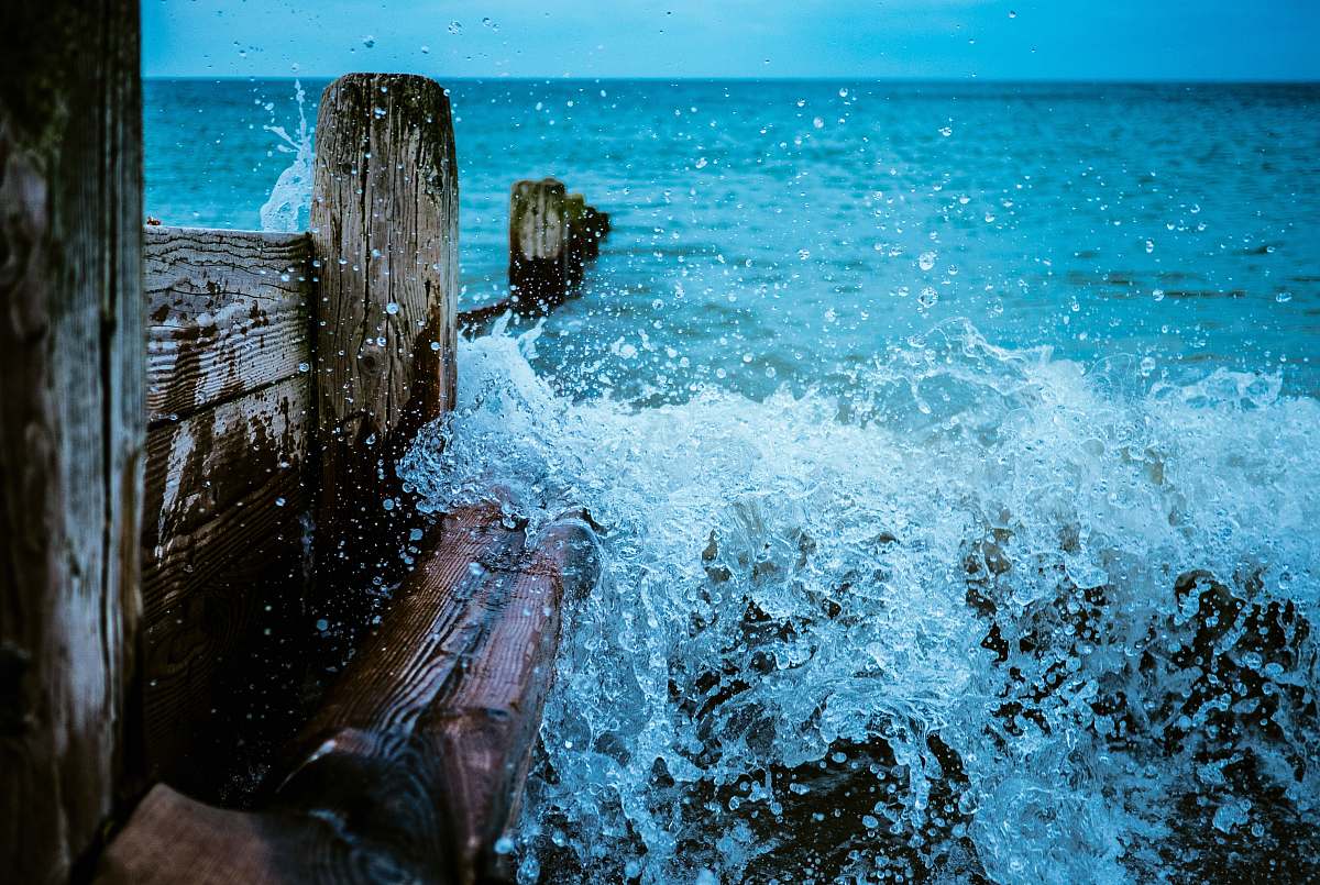 waves brown wooden dock with body of water during daytime ocean
