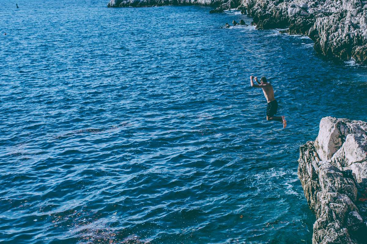 blue person jumped from rock cliff sport