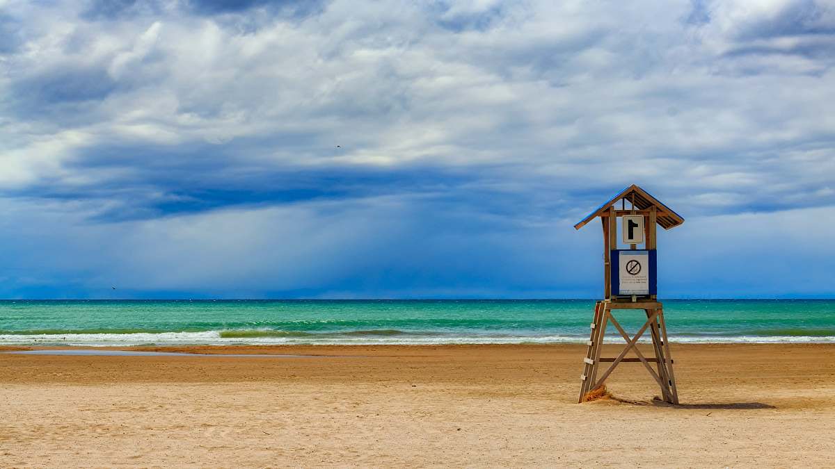 beach photo of lifeguard house on seashore during daytime sea