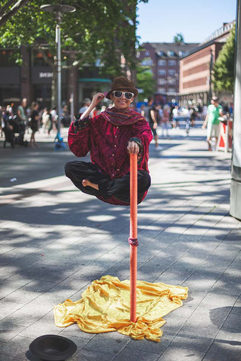 accessory man floating holding on orange stick white people watching on the street sunglasses