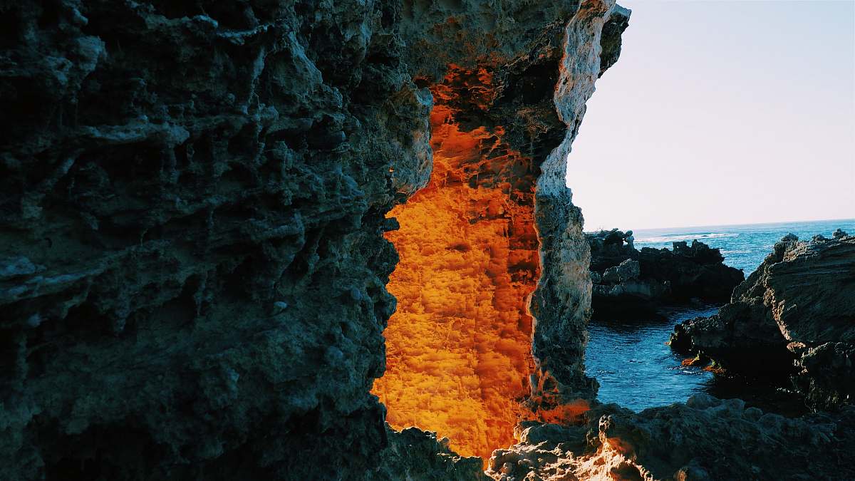 ocean lighted cave entrance near body of water sea