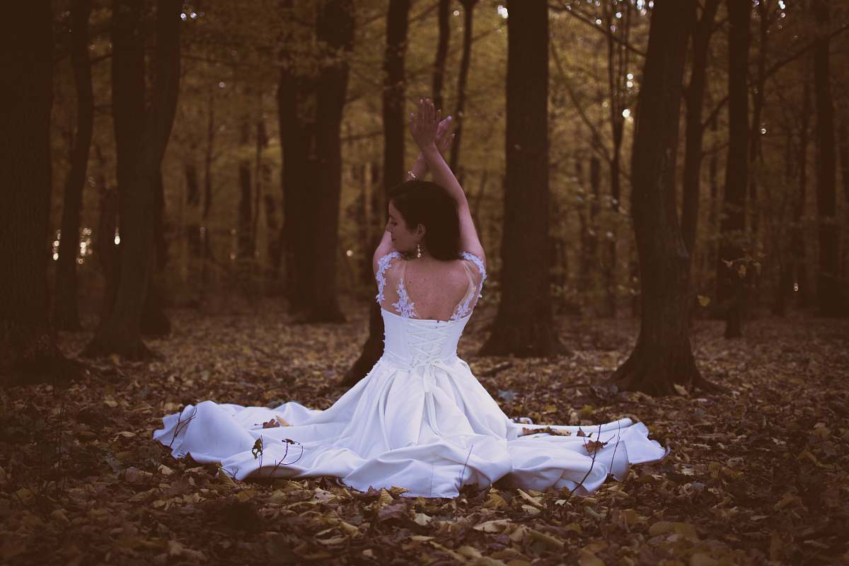 apparel woman in white sleeveless dress sitting on piles of leaves female