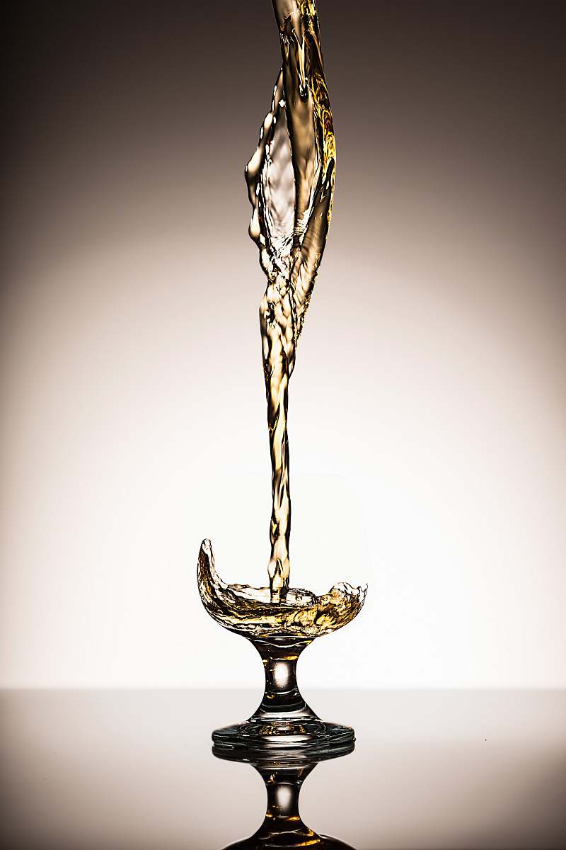 goblet liquid pouring on clear short-stem wine glass liquid