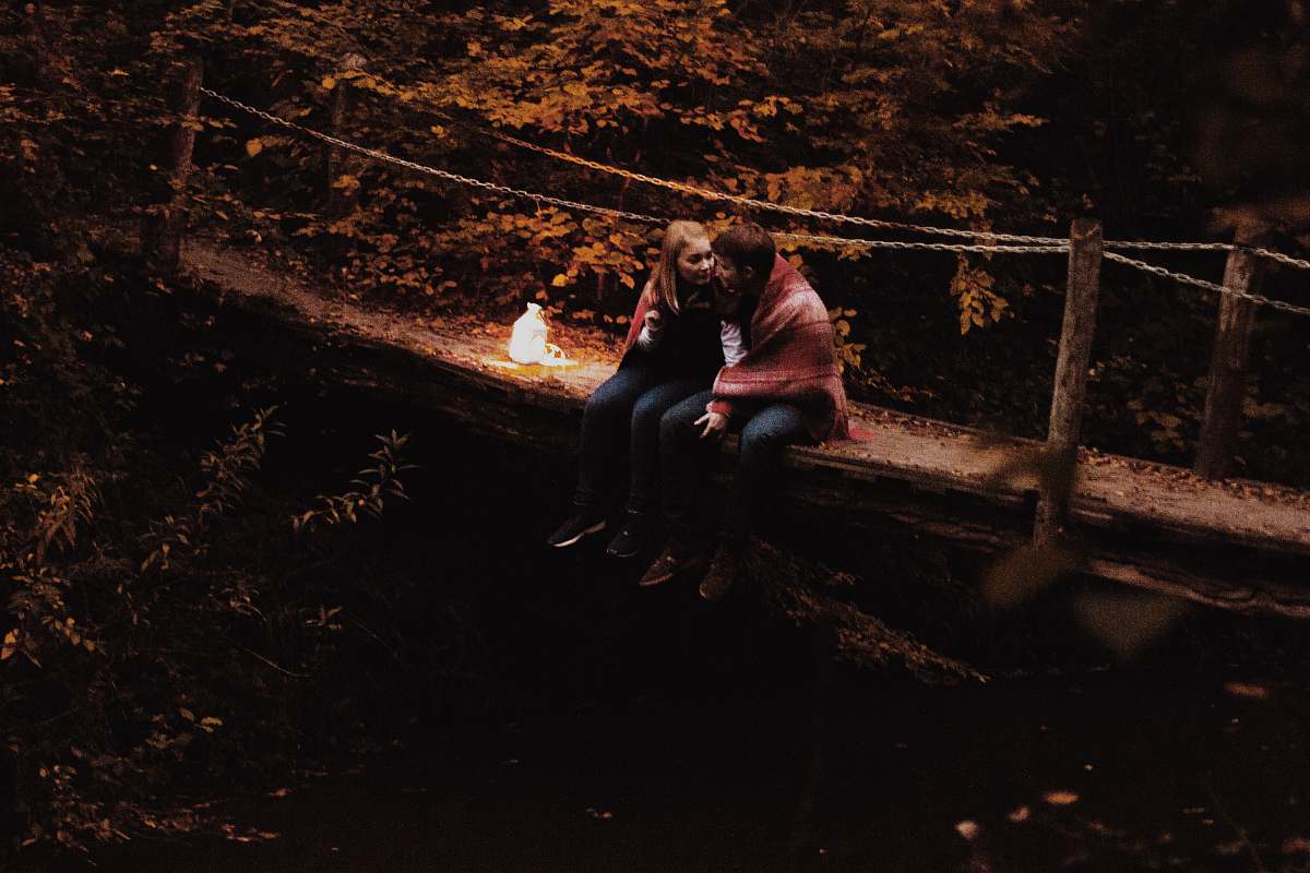 person couple sitting on bridge people